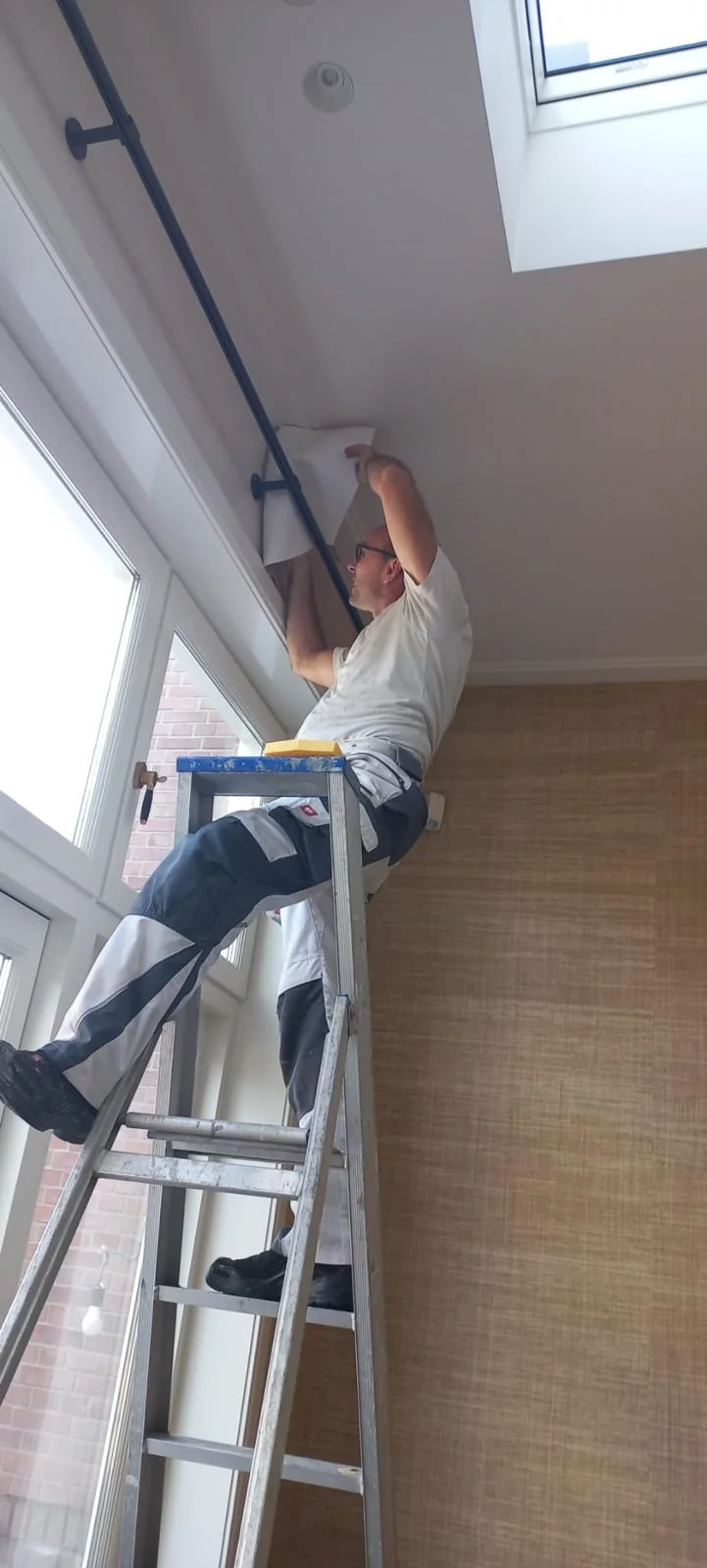 Wandbekleding die doorloopt tot aan het plafond en het raam.