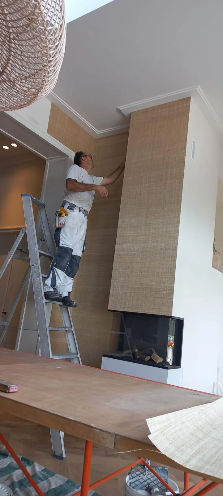 Precisiewerk tijdens het aanbrengen van luxe structuurbehang